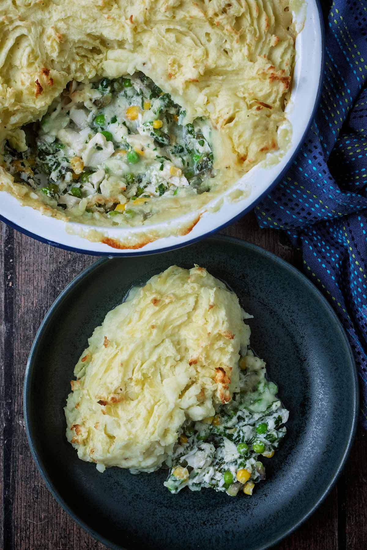 A portion of fish pie removed from a baking dish and placed on a plate.
