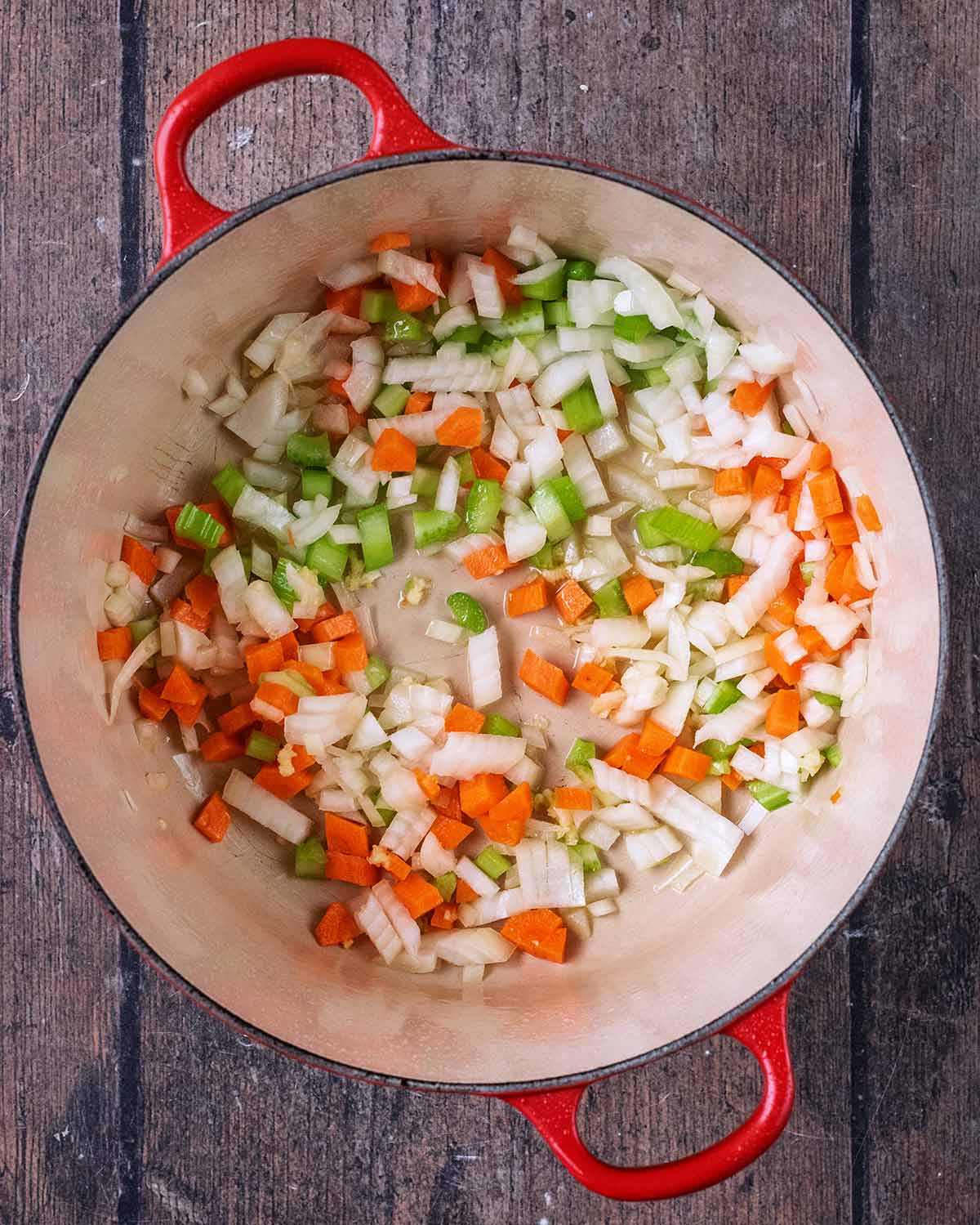 Chopped onion, celery and carrot cooking in a large pan.