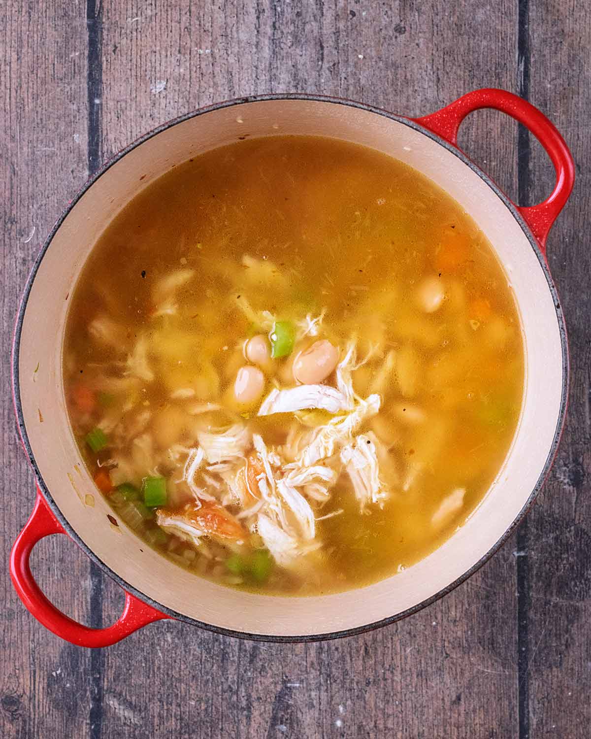 Shredded chicken and stock added to the pan.