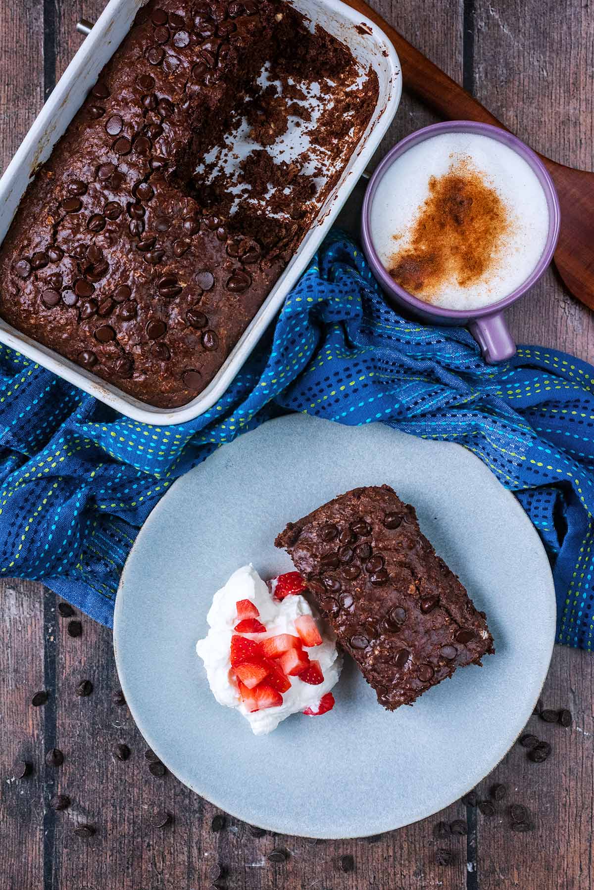 A portion of chocolate baked oats next to a baking dish of more baked oats.