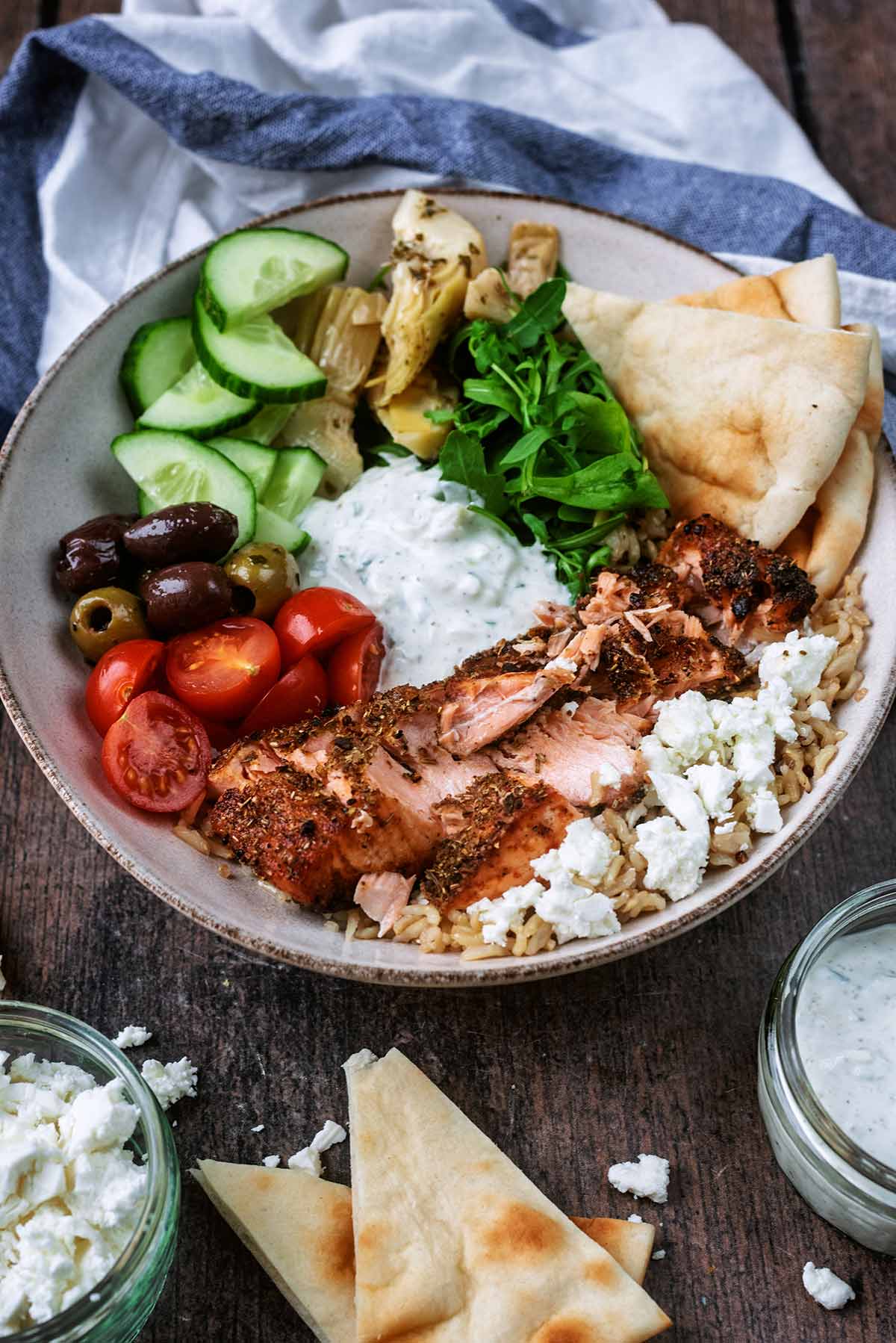 A bowl of salmon and rice salad in front of a striped towel.