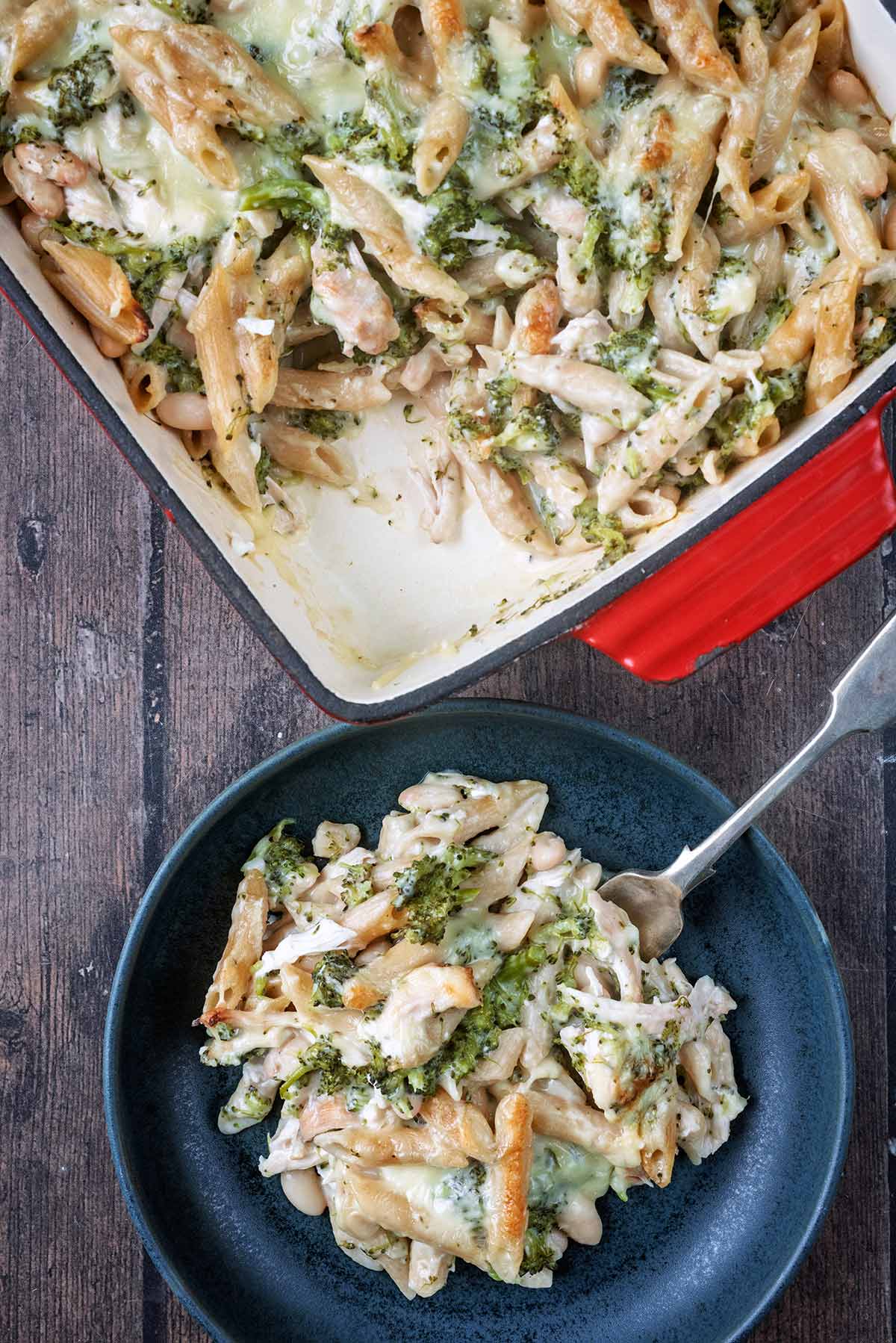 A plate of pasta bake next to a baking dish of more pasta bake.
