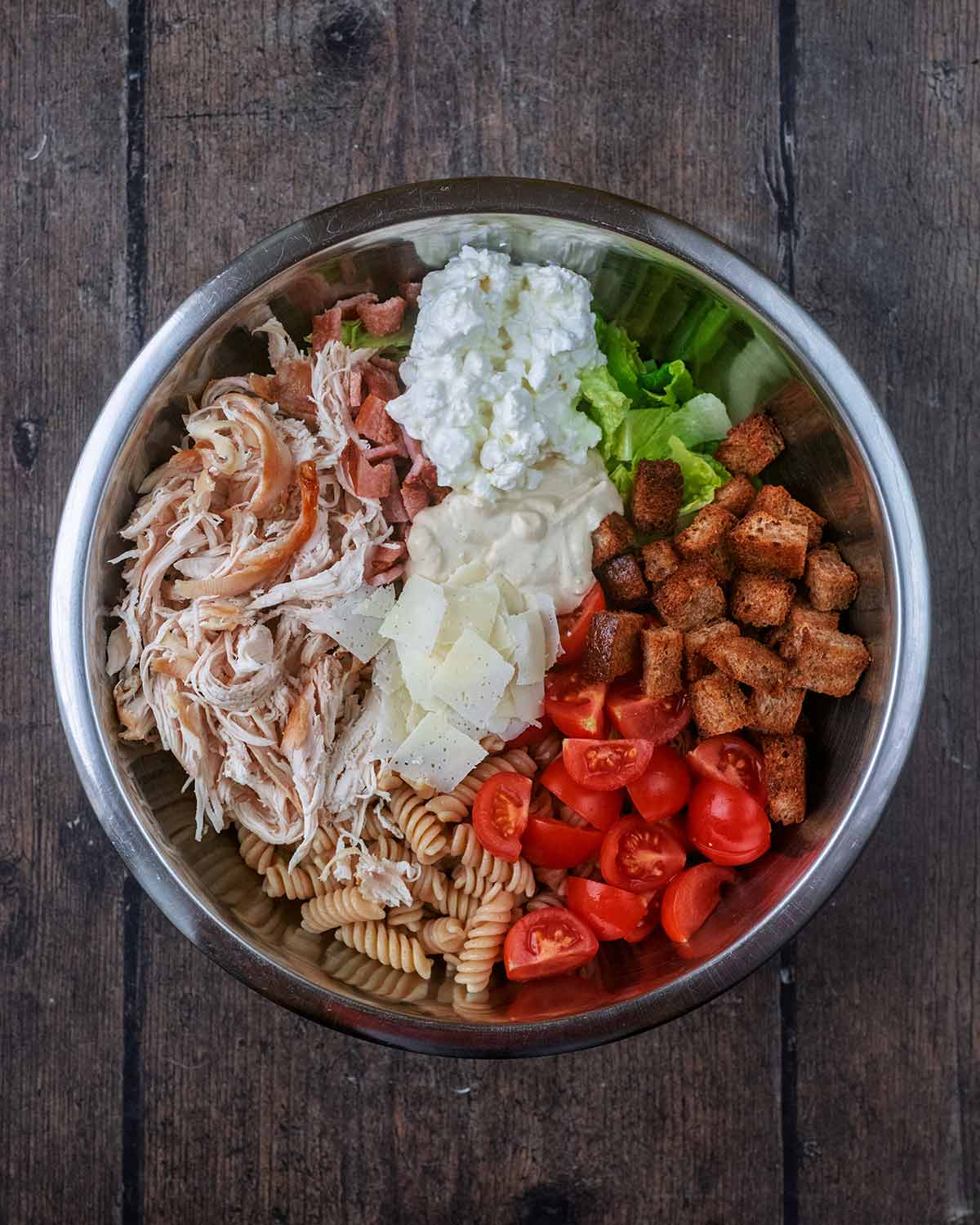 Cottage cheese, salad dressing and parmesan shavings added to the bowl.