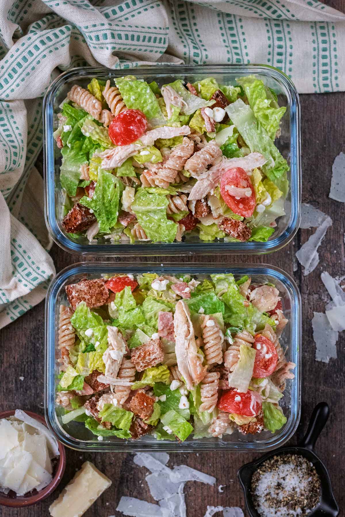 Two glass storage containers containing pasta salad.