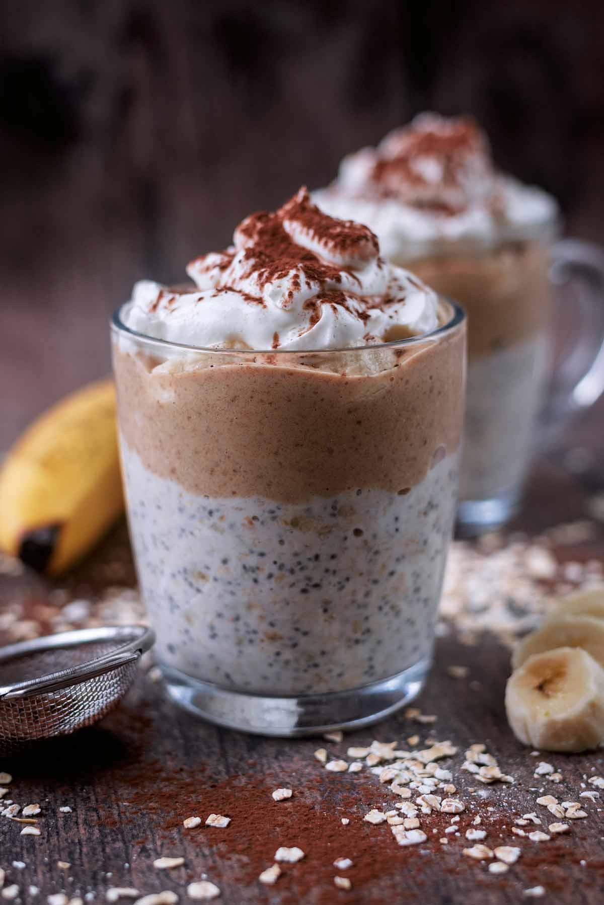 Two glasses of overnight oats layered with oats, caramel and thick yogurt.