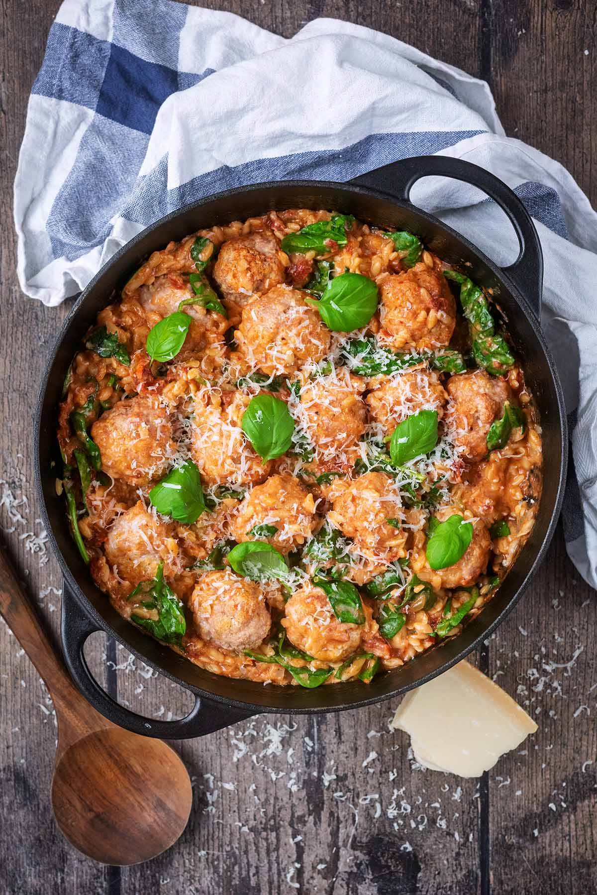A large black cooking pan containing meatballs in a creamy sauce.