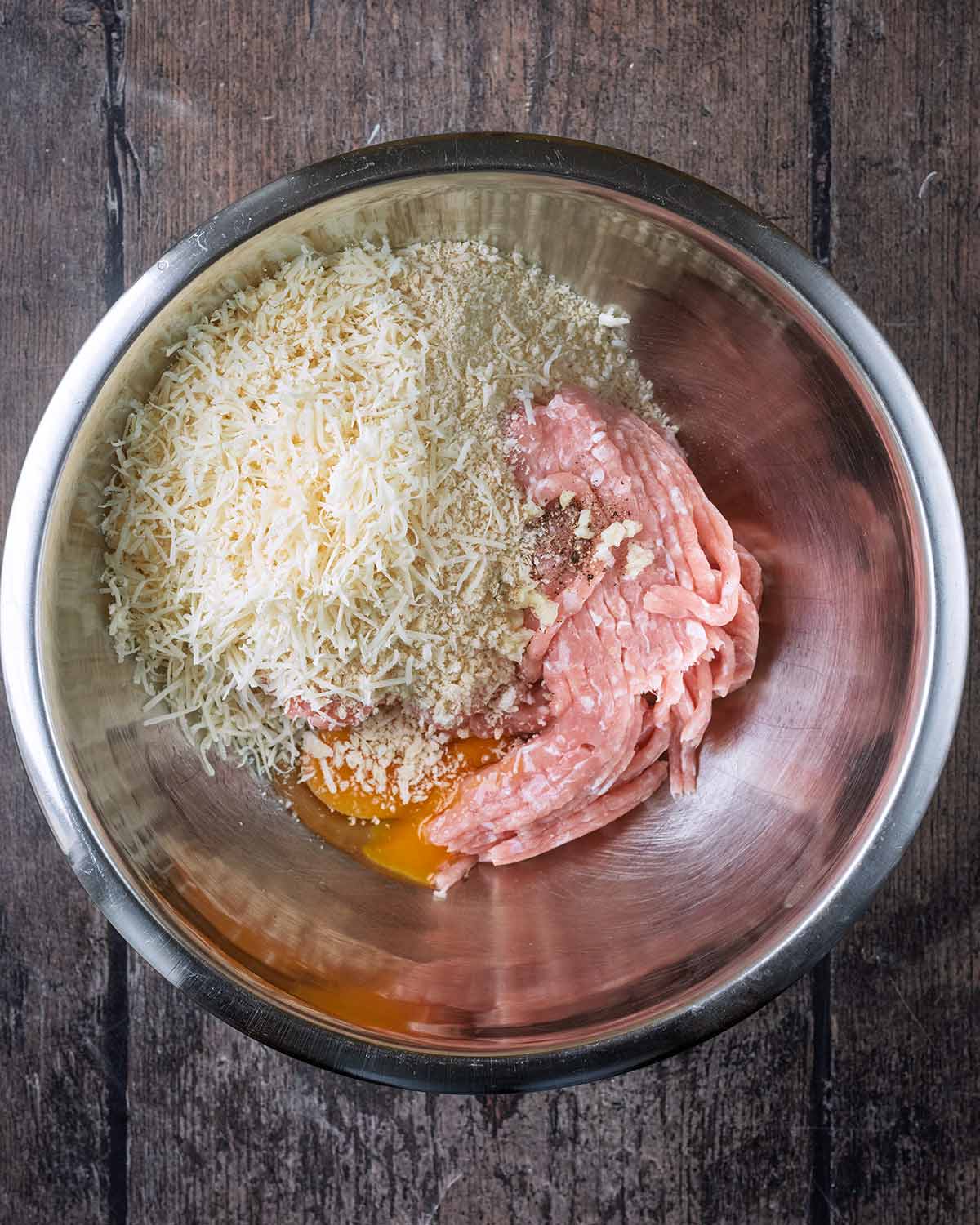 Chicken mince, breadcrumbs and grated parmesan in a mixing bowl.