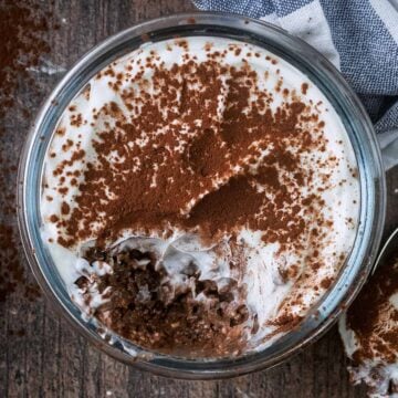 A glass jar full of tiramisu overnight oats with a spoonful removed.