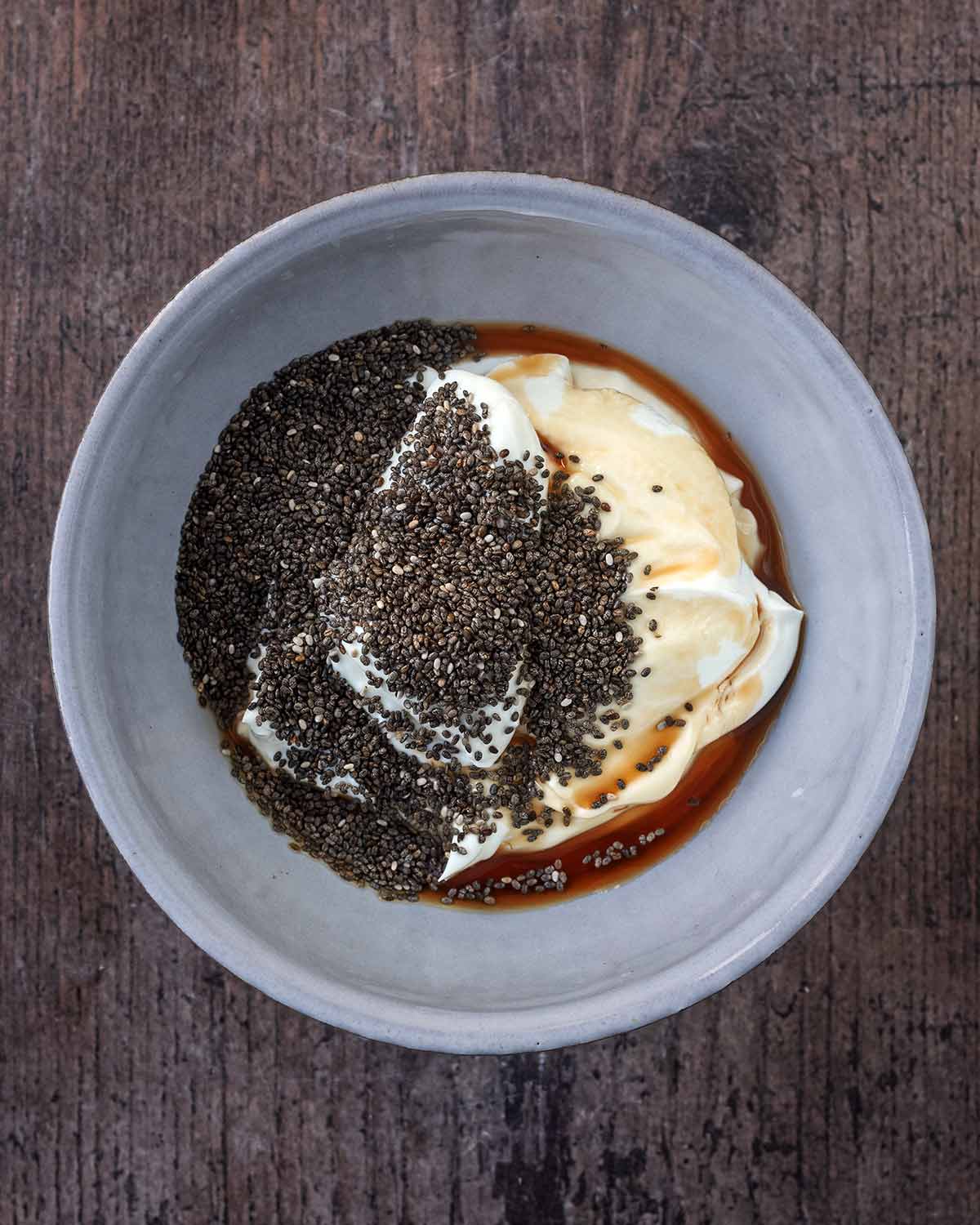 A bowl containing yogurt, vanilla and chia seeds.