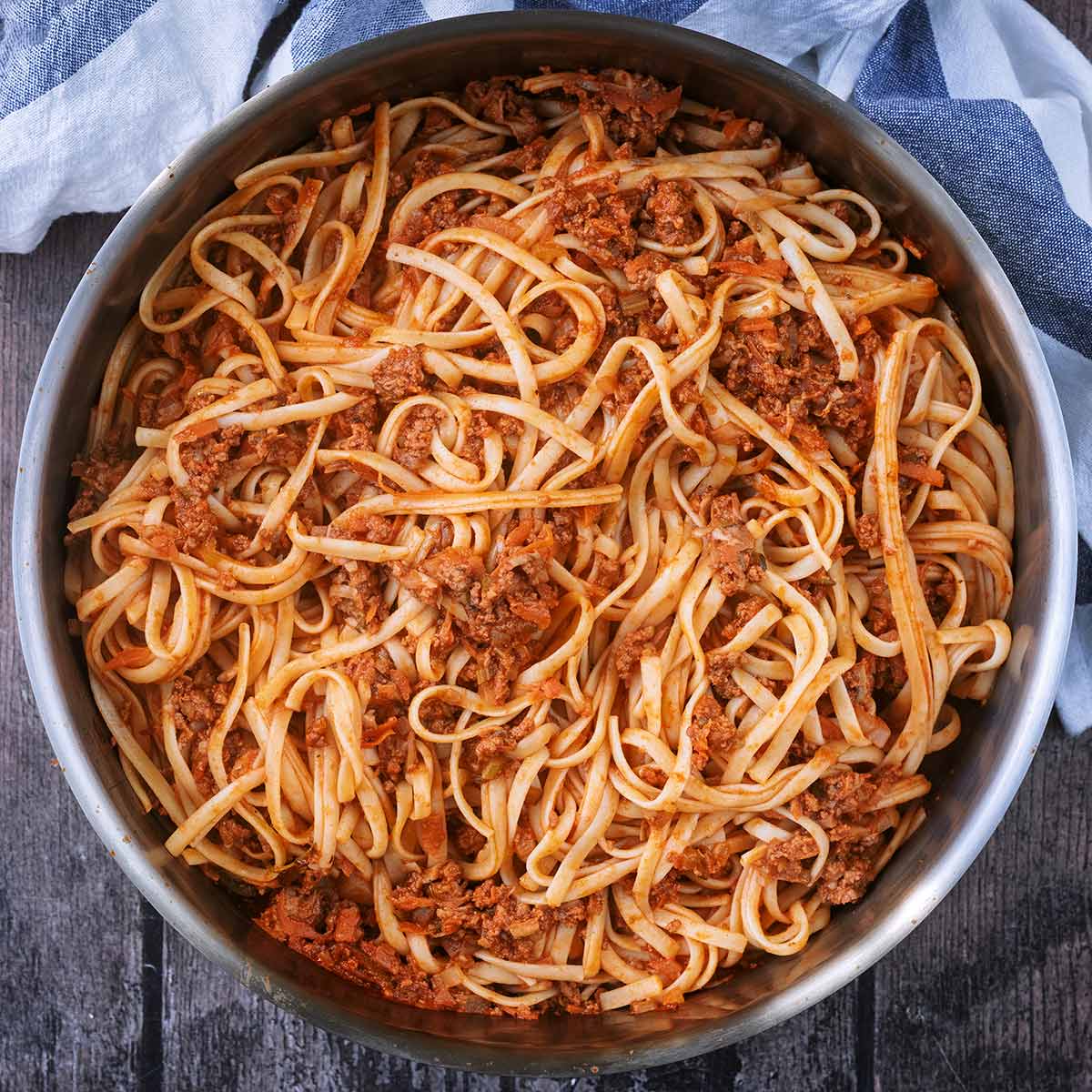 Hidden vegetable bolognese in a large silver pan.
