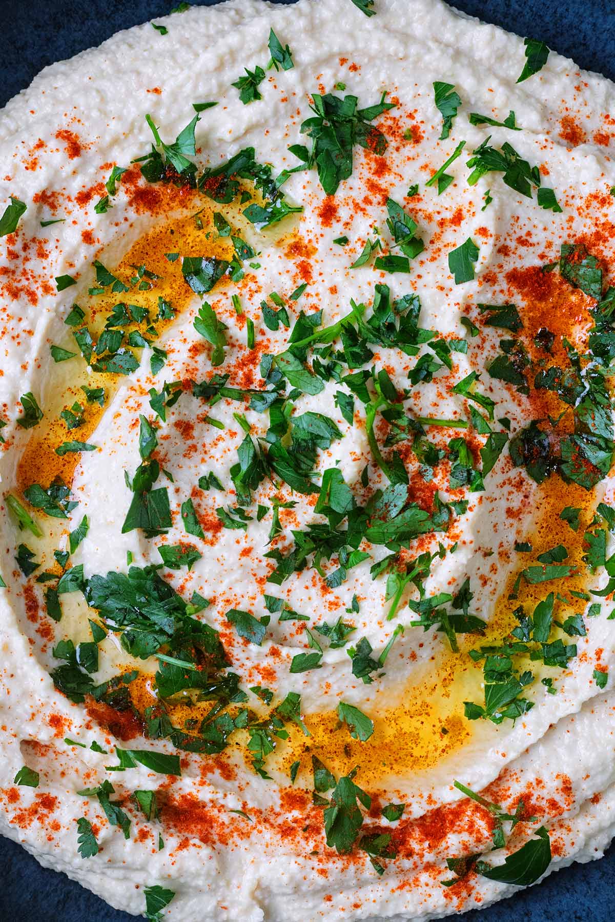 Hummus topped with olive oil, paprika and chopped parsley.