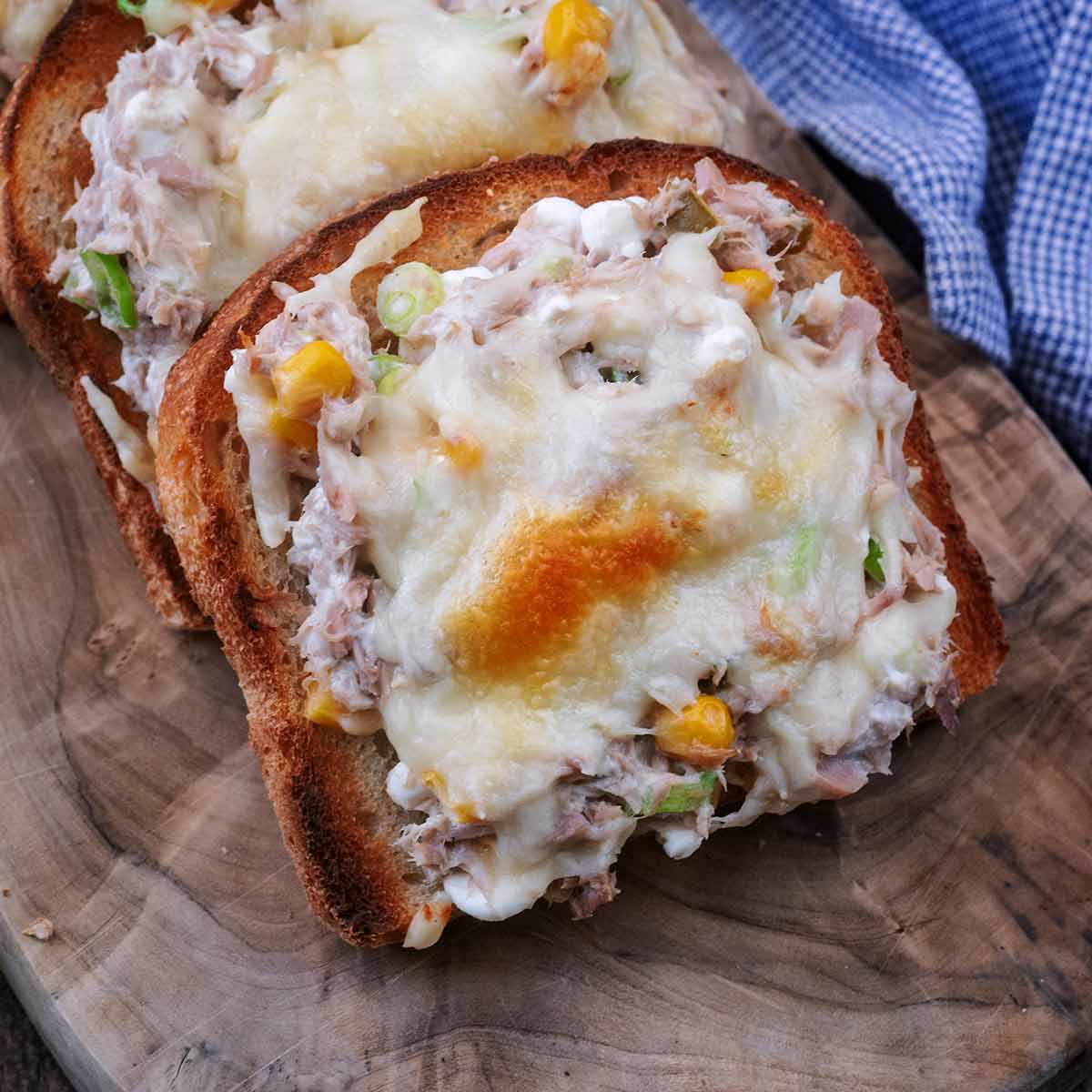 A slice of high protein tuna melt on a wooden board.