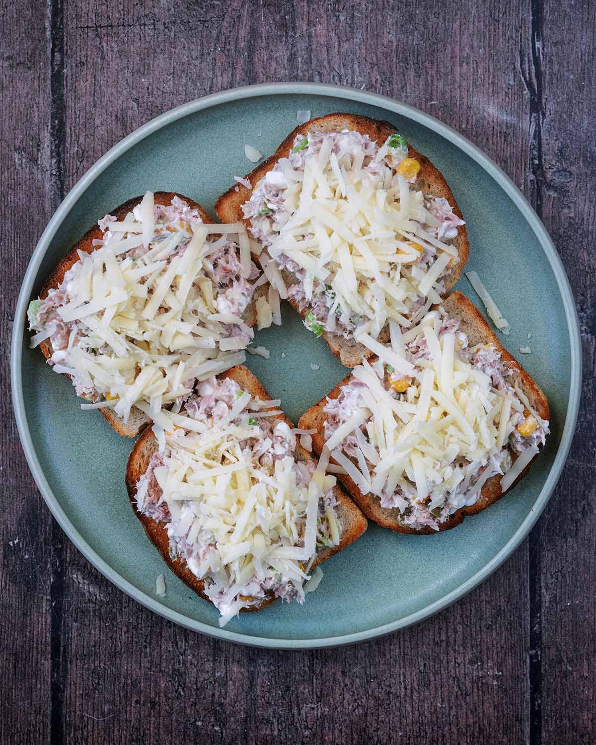 Grated cheddar added on top of the tuna mixture.