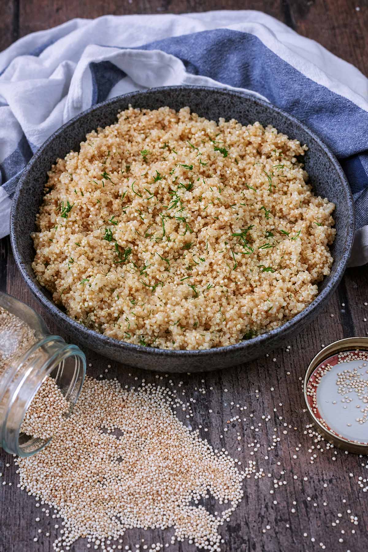A bowl of cooked quinoa in front of a striped towel.