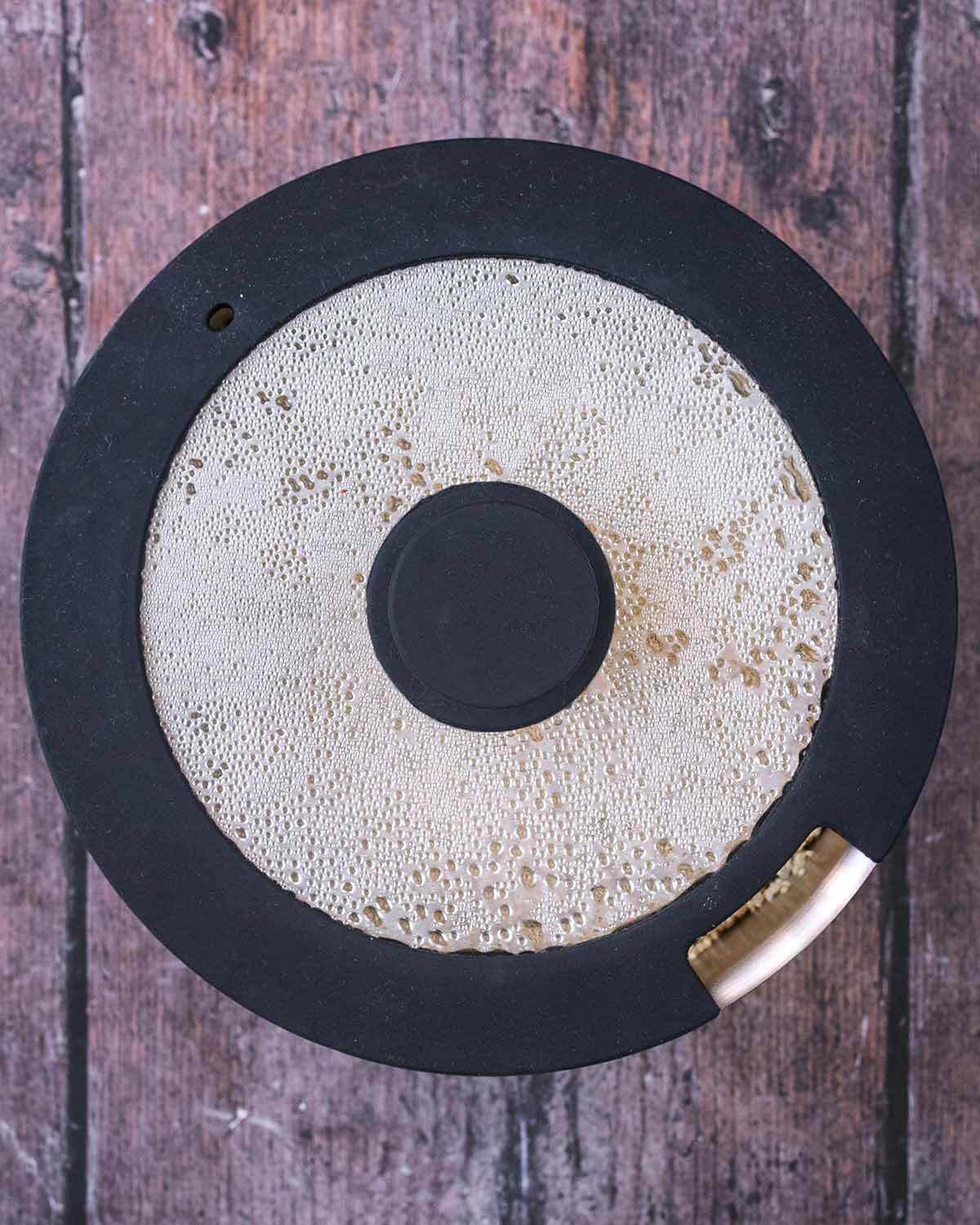 A lid put on the saucepan of quinoa.