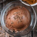A ball of chocolate peanut butter ice cream in a serving glass.