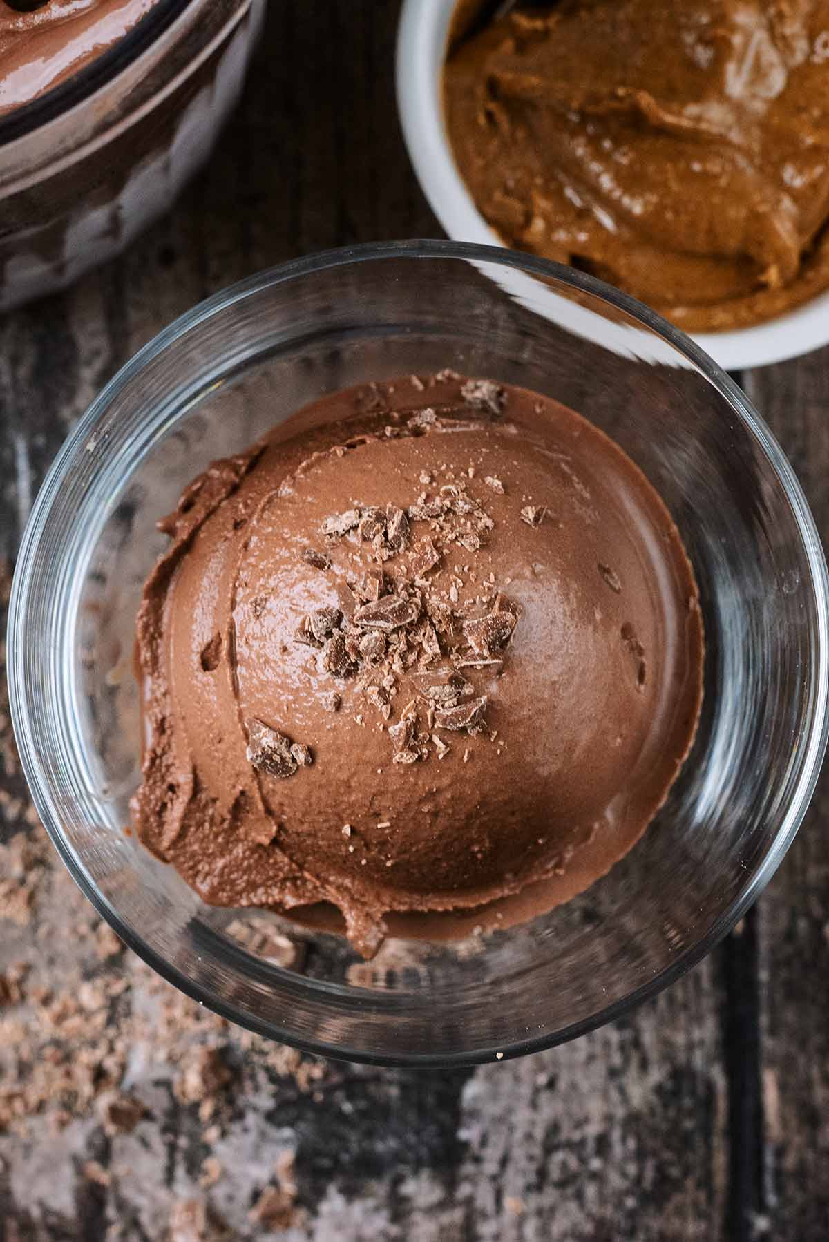 A ball of chocolate ice cream topped with grated chocolate.