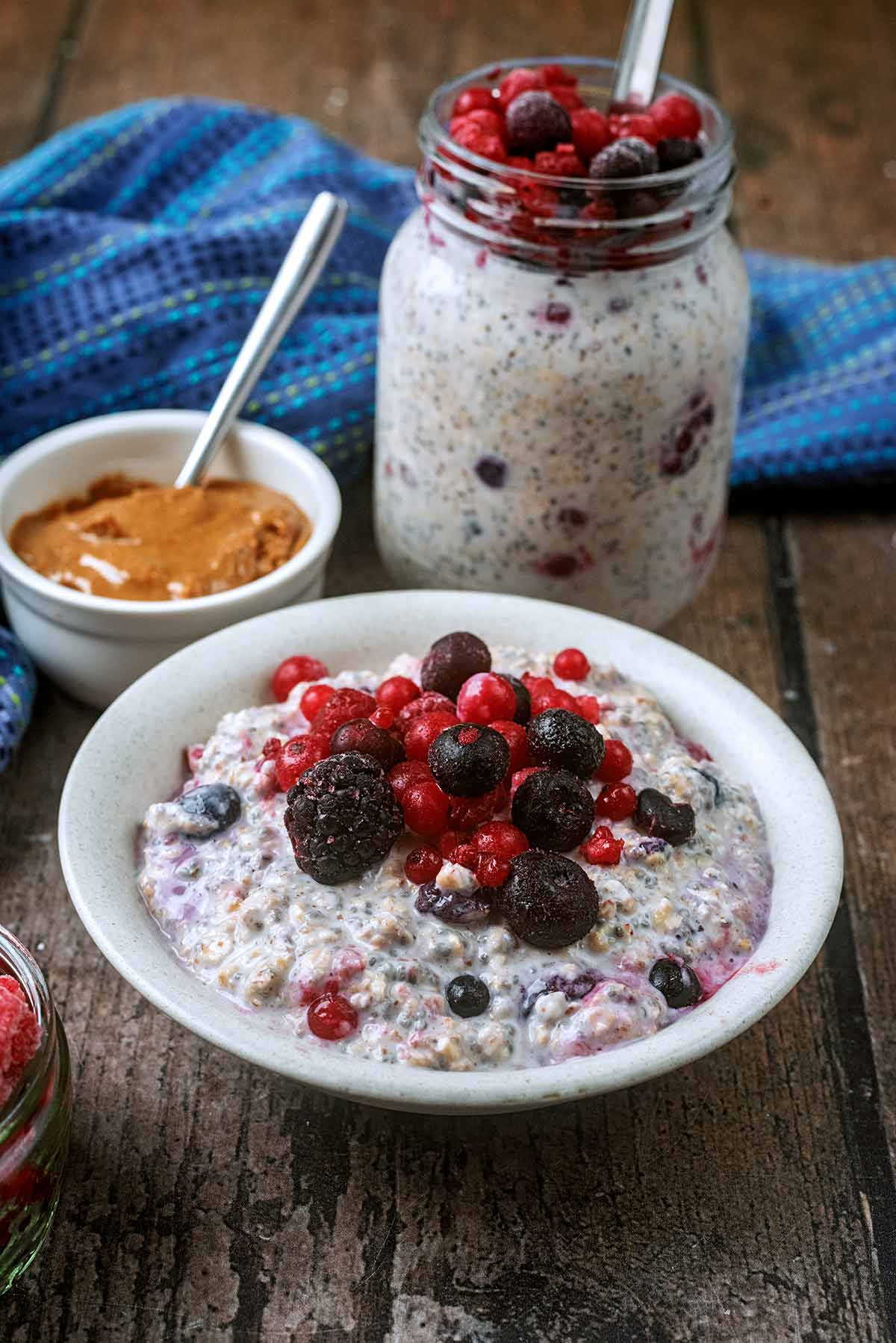 A bowl of overnight oats with a jat full of overnight oats in the background.