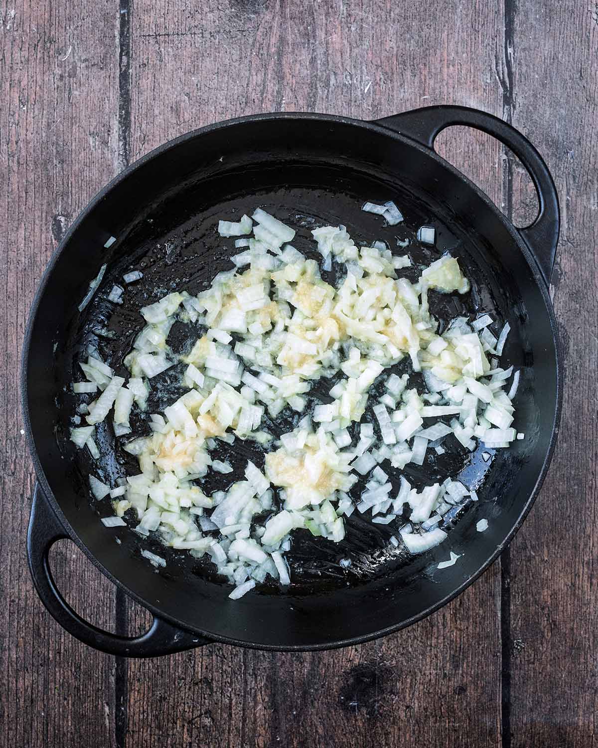 Diced onions, garlic paste and ginger paste cooking in a large pan.