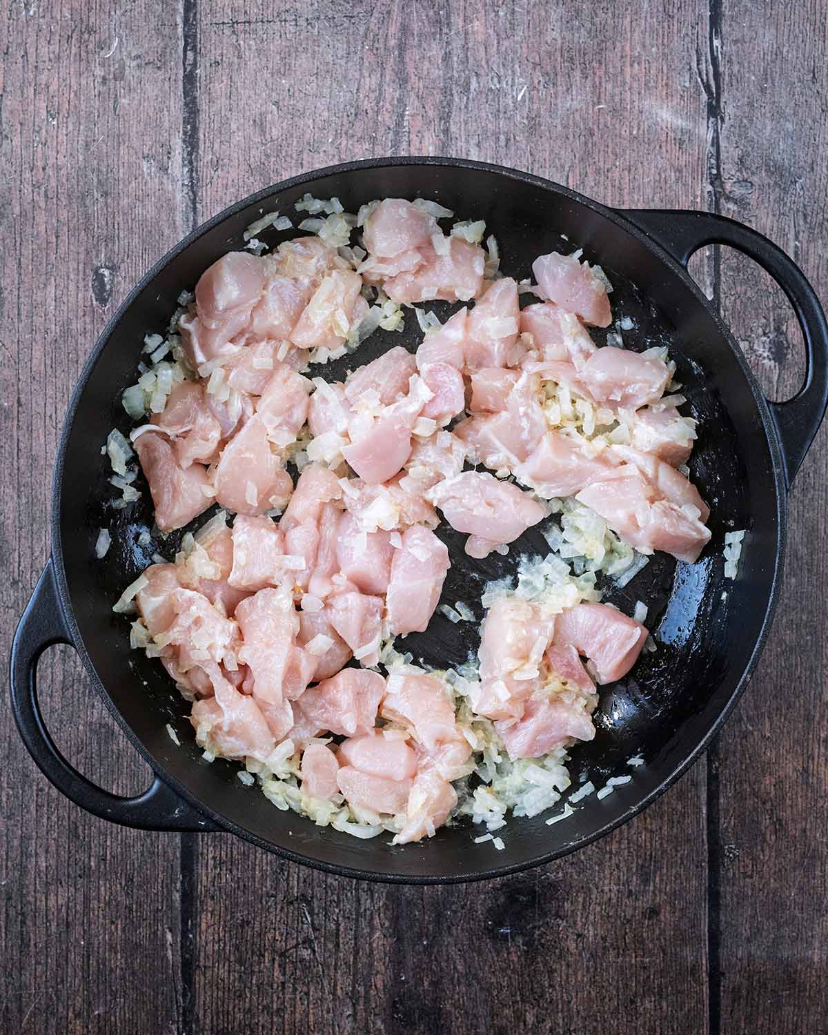 Diced chicken breast added to the pan.