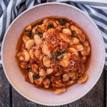 Slow cooker butter beans in a round pink bowl.