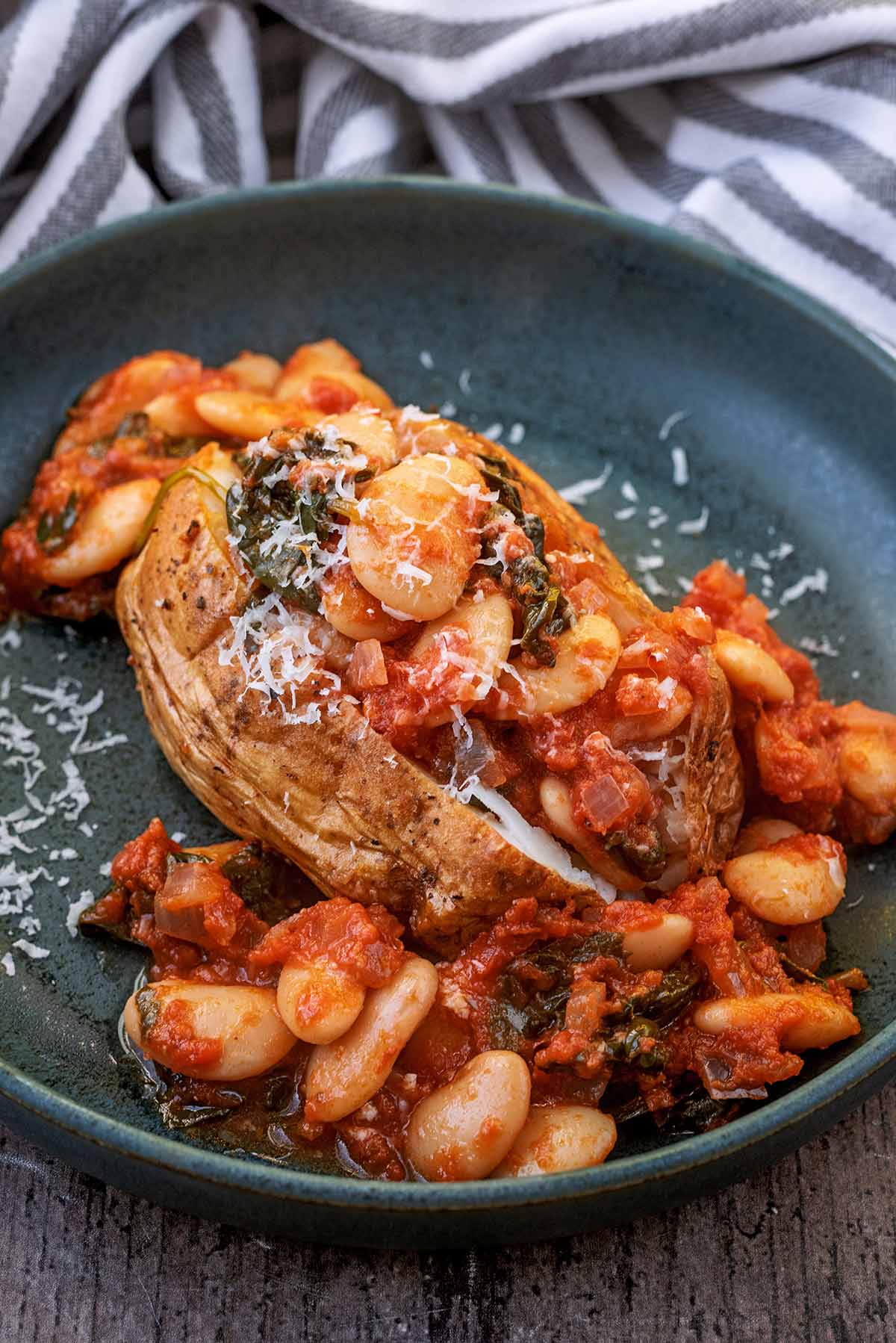 A jacket potato topped with butter beans in a tomato sauce.
