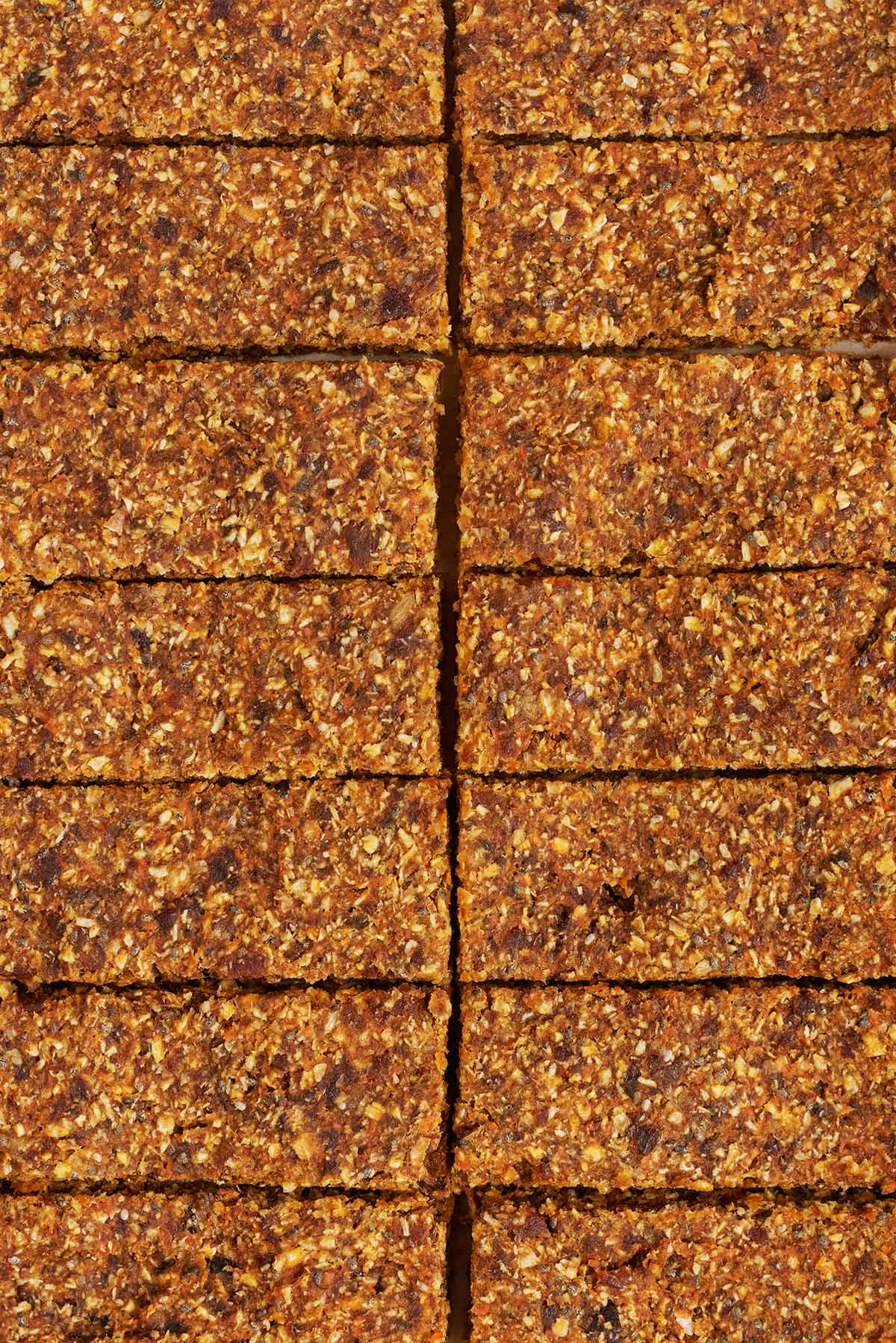 A slab of cooked oat bar cut into fourteen equal sized bars.
