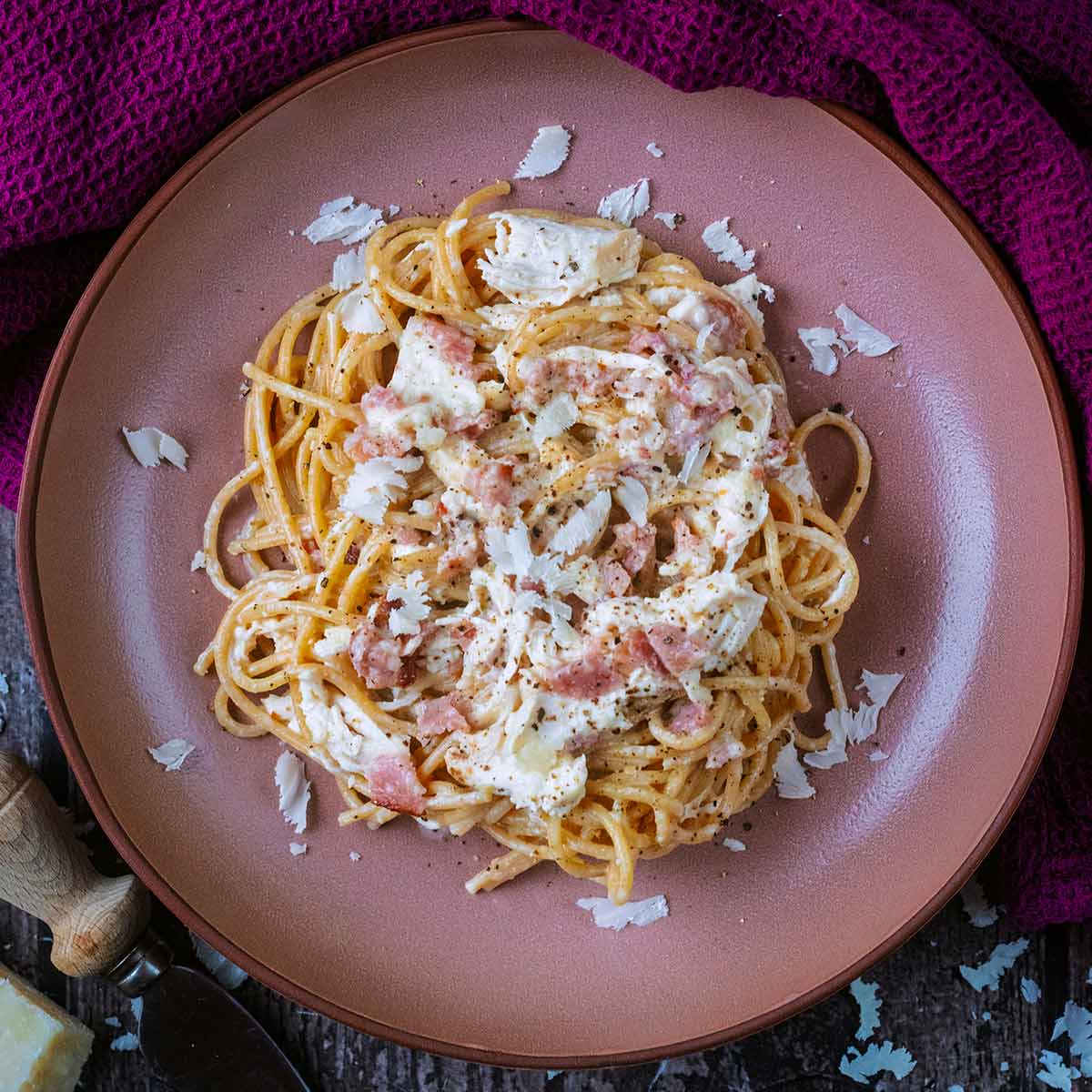 Chicken carbonara in a pink bowl.