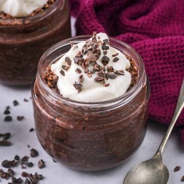 A glass jar full of chocolate cherry overnight oats.