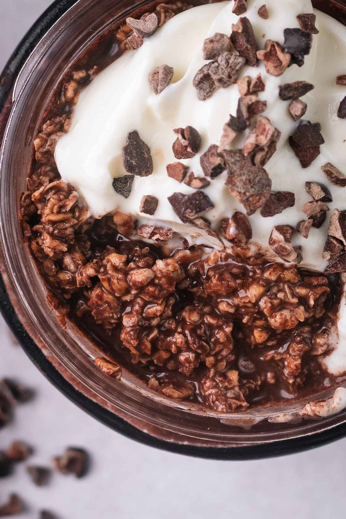 Chocolate overnight oats topped with yogurt and cacao nibs.