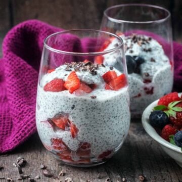 A glass full of cottage cheese chia pudding and berries.