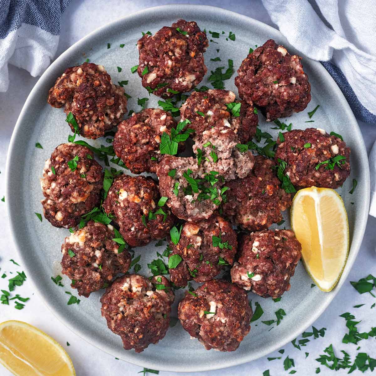 A plate full of cottage cheese meatballs with a lemon wedge.