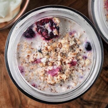 Cottage cheese overnight oats and berries in a glass jar.