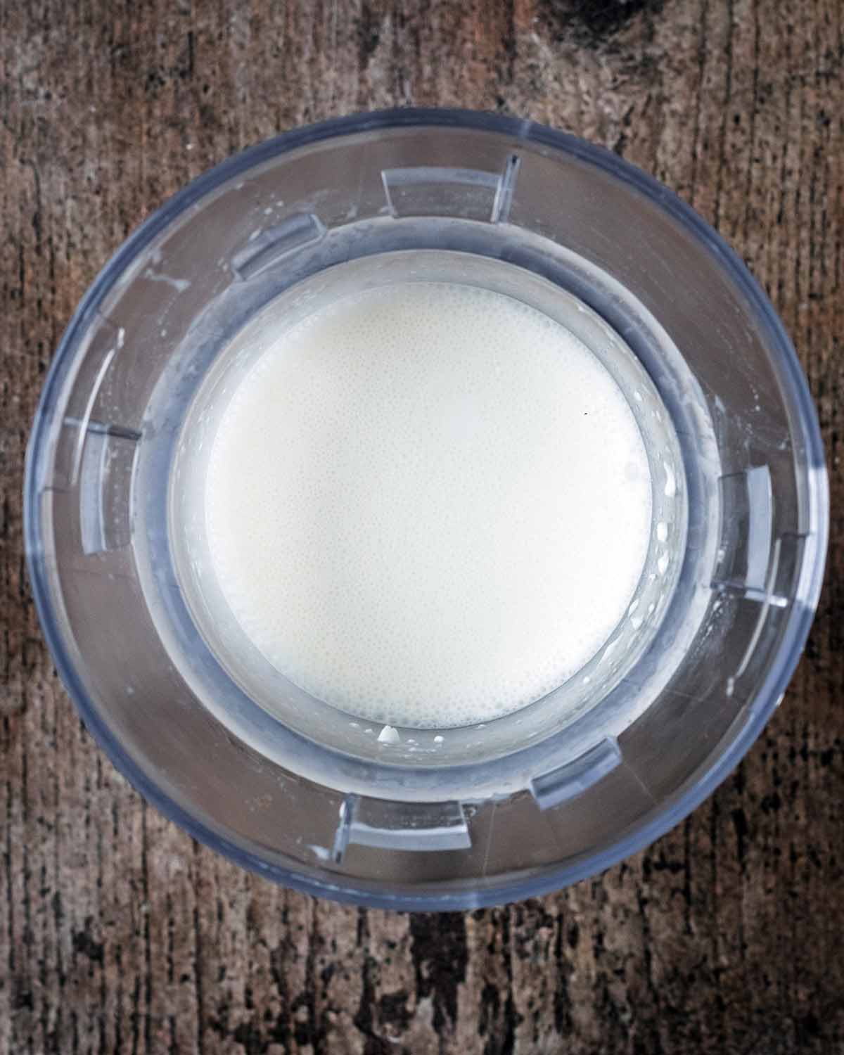 Cottage cheese and milk blended together in a blender jug.