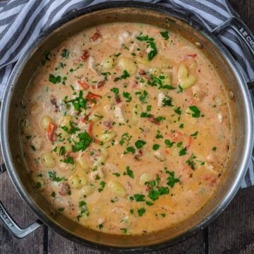 Creamy tomato and chicken gnocchi in a large silver pan.