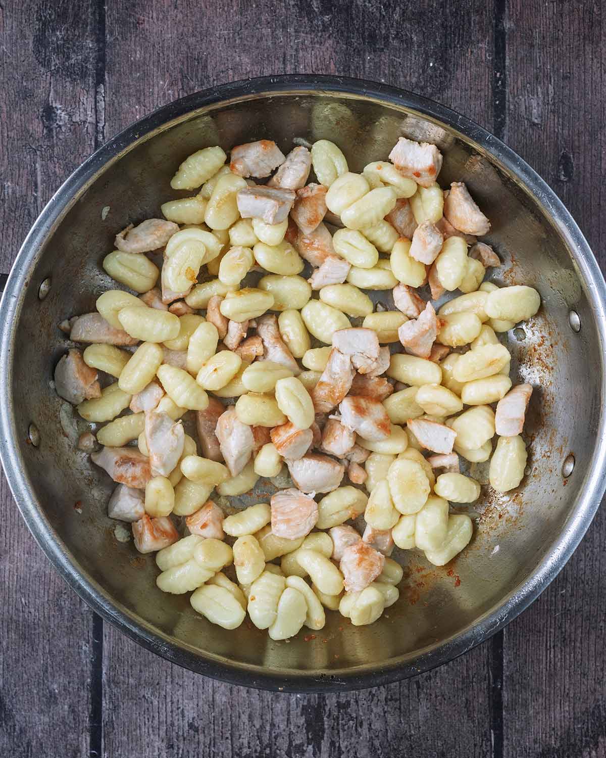 Gnocchi added to the pan of chicken.