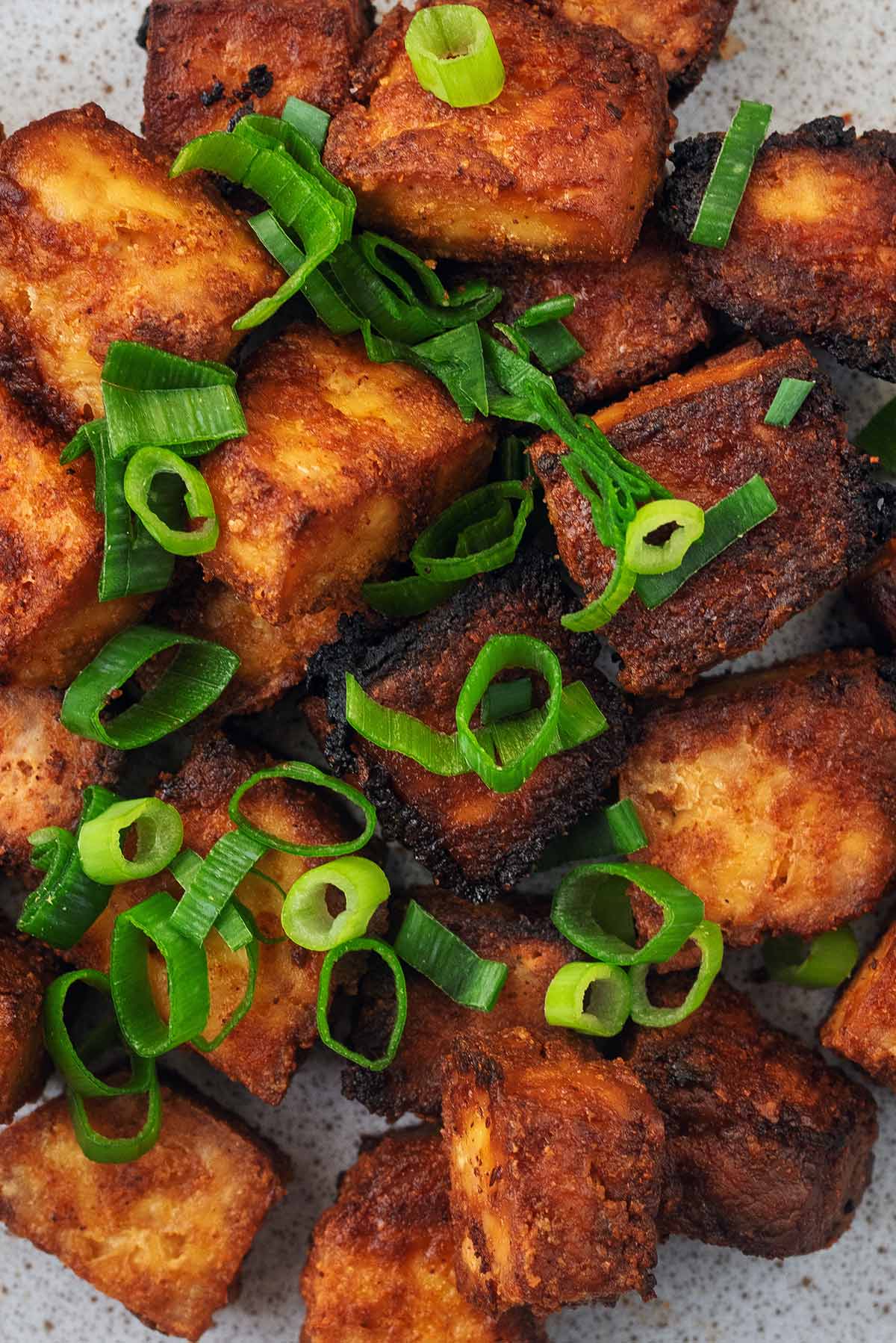 Crispy cubes of tofu topped with sliced spring onions.