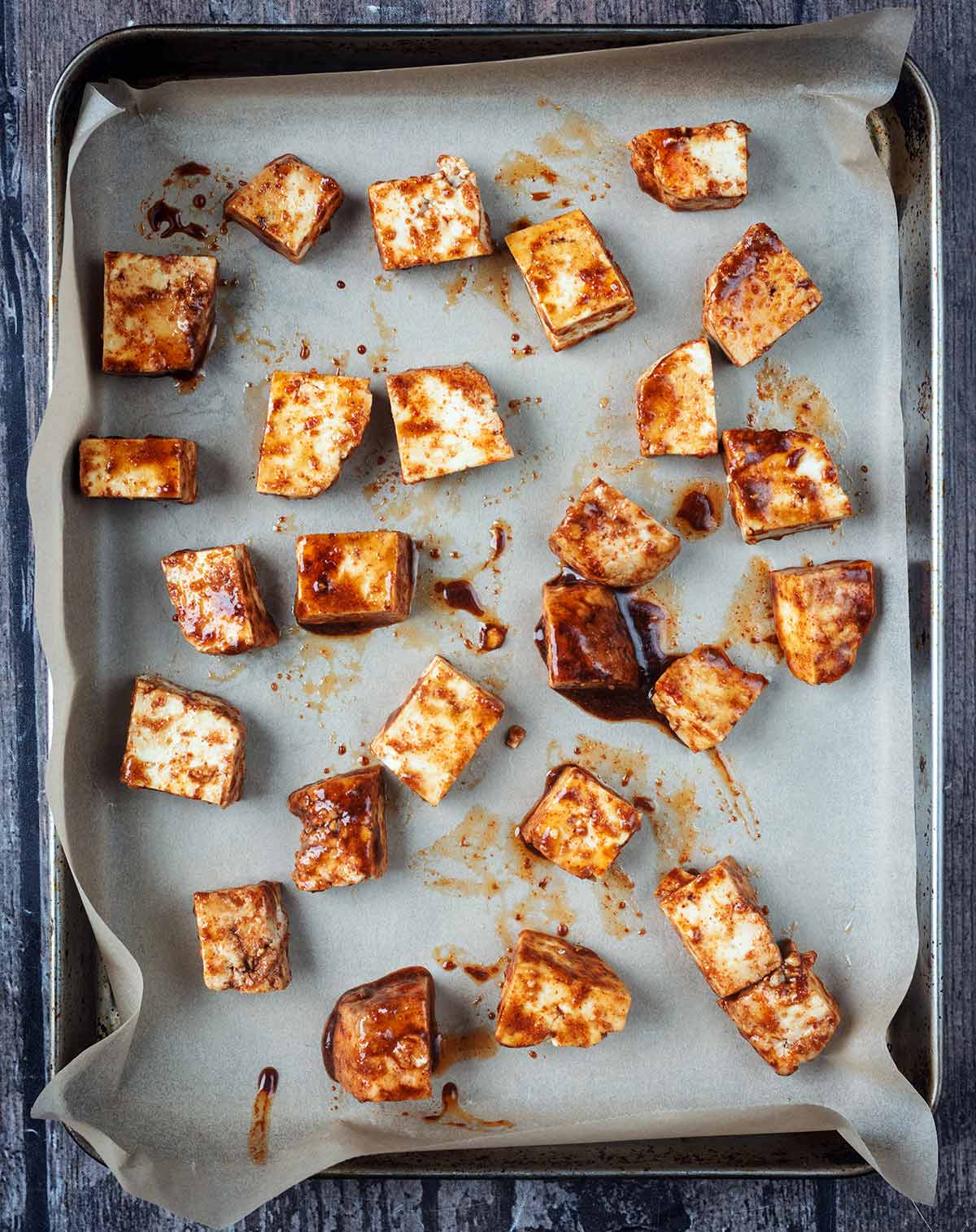 Coated tofu cubes on a baking tray.