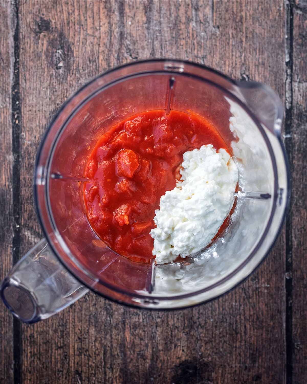 Chopped tomatoes and cottage cheese in a blender jug.