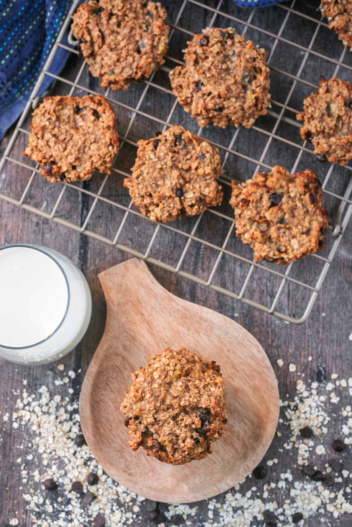 Cookies on a cooling rack next to more cookies on a small round wooden board.