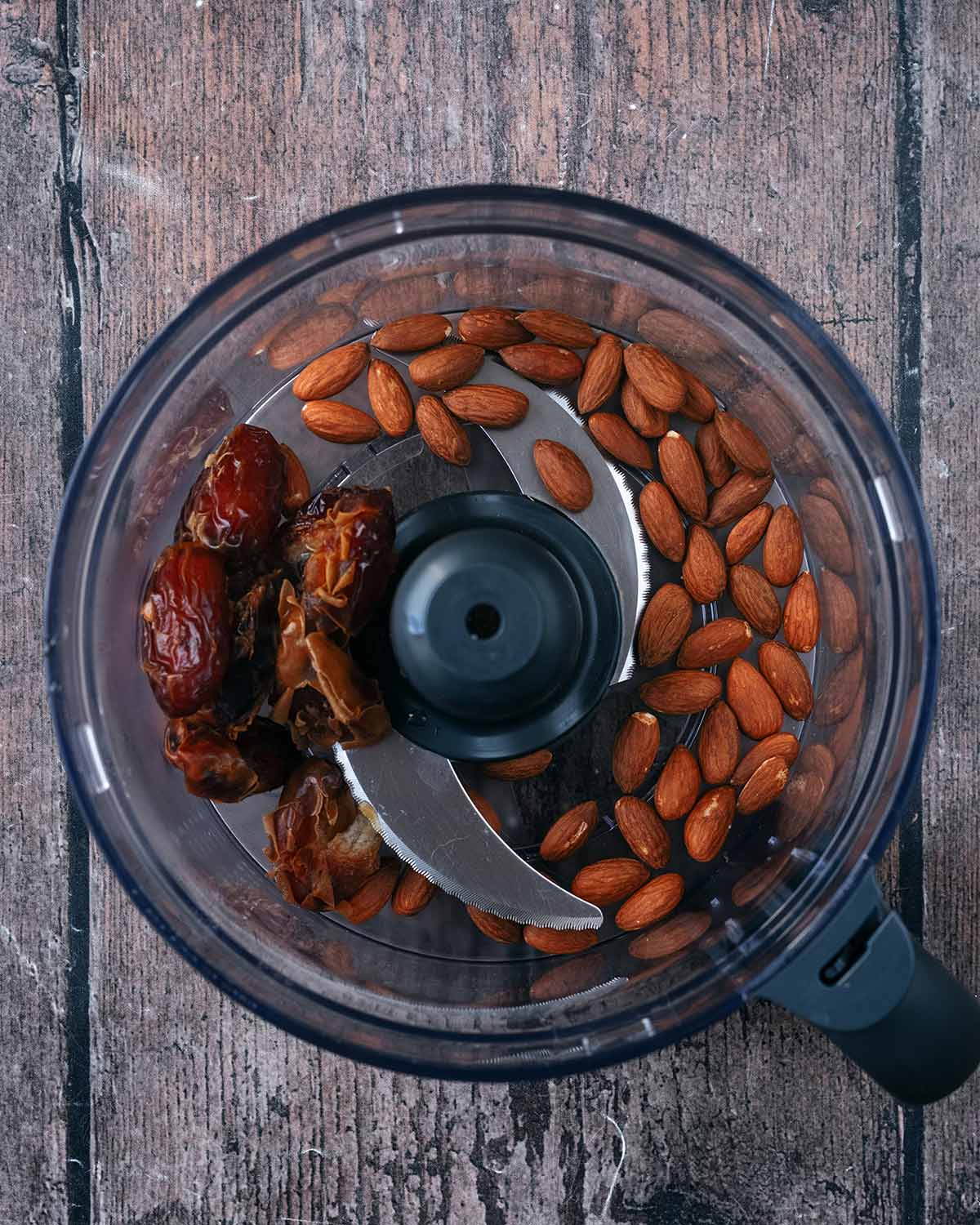 A food processor containing almonds and dates.