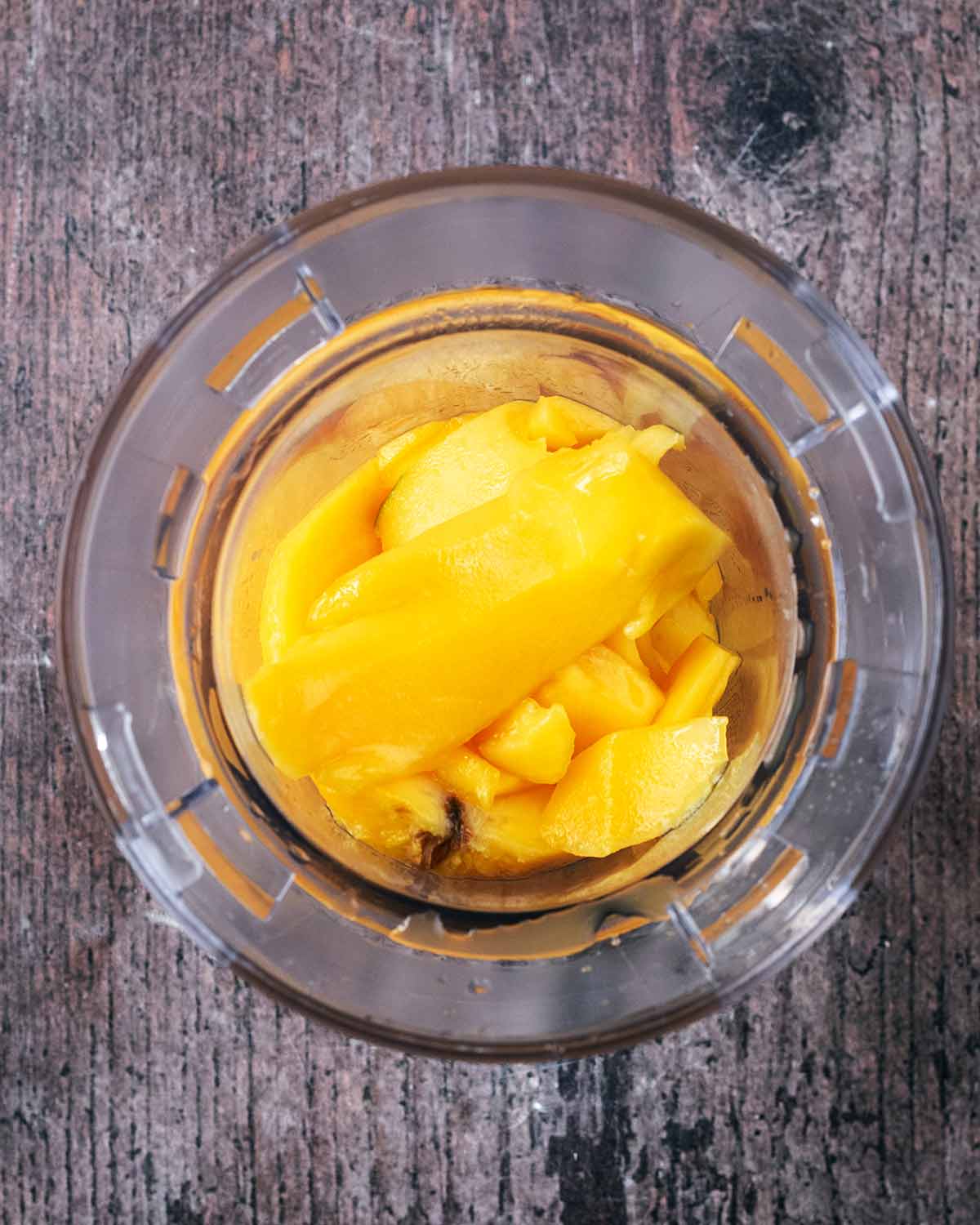 Chunks of mango in a small blender jug.