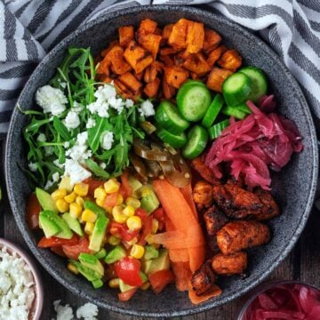 Hot honey chicken bowl next to a striped towel.