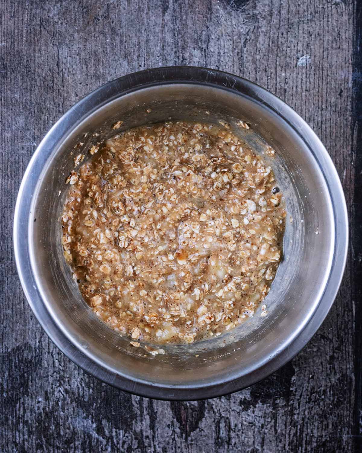 A bowl of oats, mashed banana, egg, flaxseeds and cinnamon.