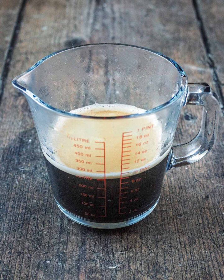 A measuring jug half filled with brewed coffee.