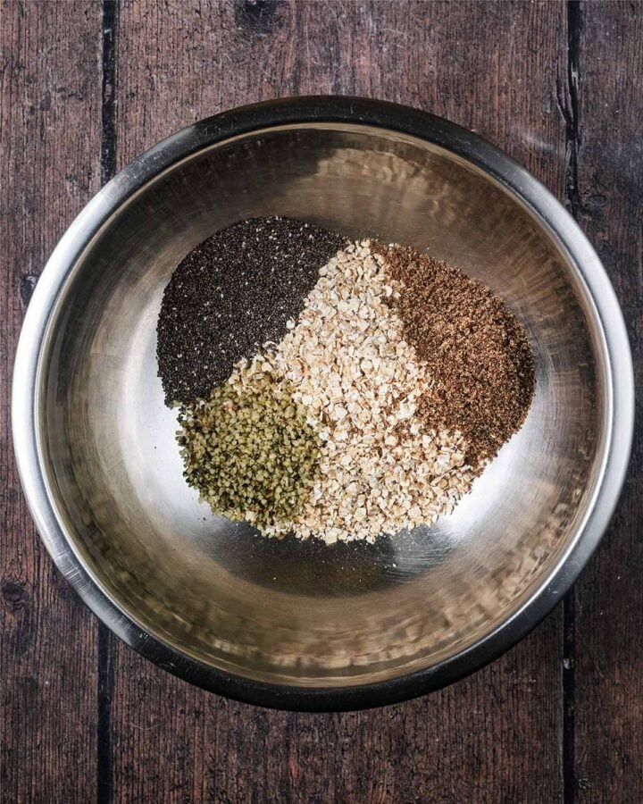 Oats and seeds in a metal mixing bowl.