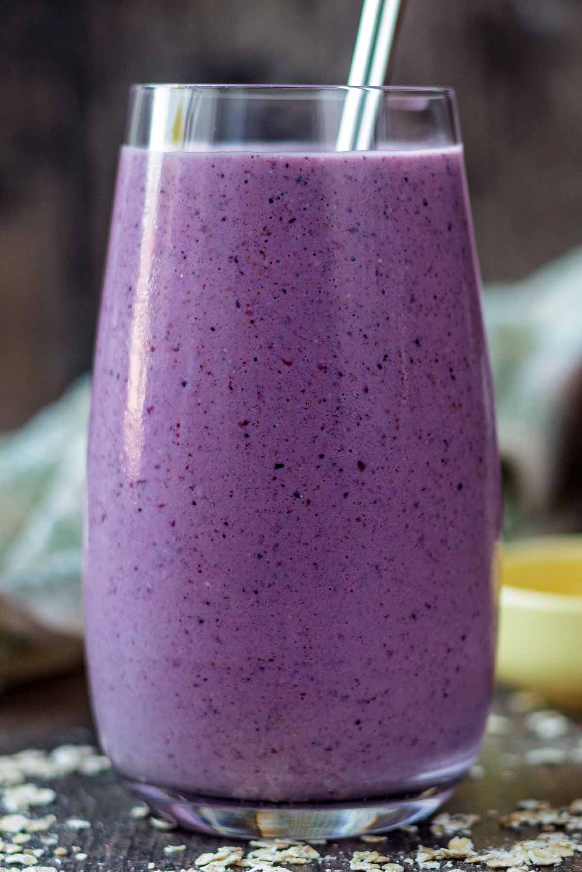A tall glass containing purple smoothie