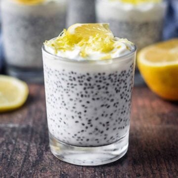 Lemon chia pudding in a glass in front of a lemon half.