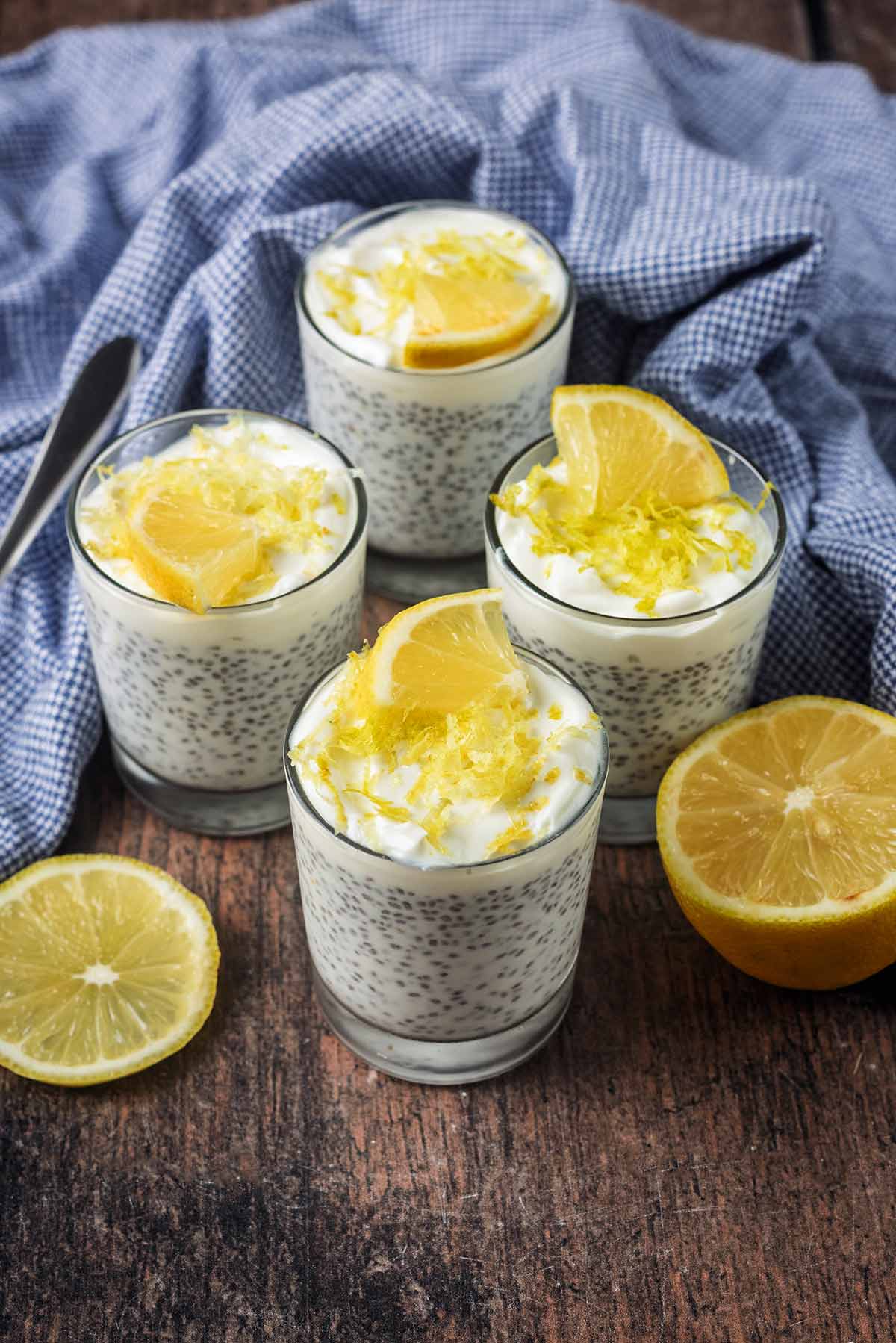 Four lemon chia puddins in front of a blue towel.