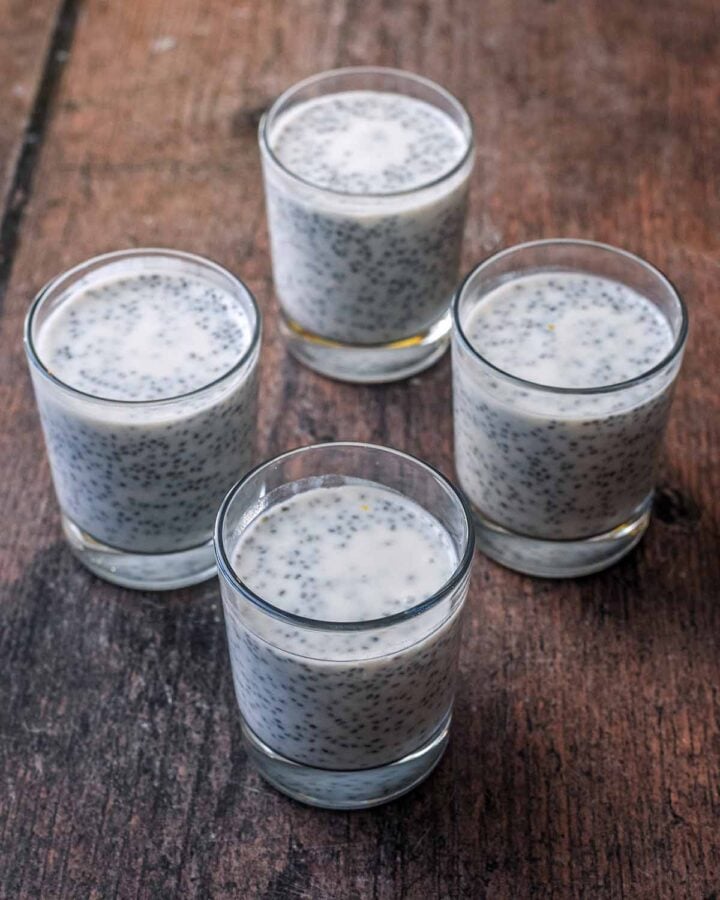 Four serving glasses filled with chia pudding mix.